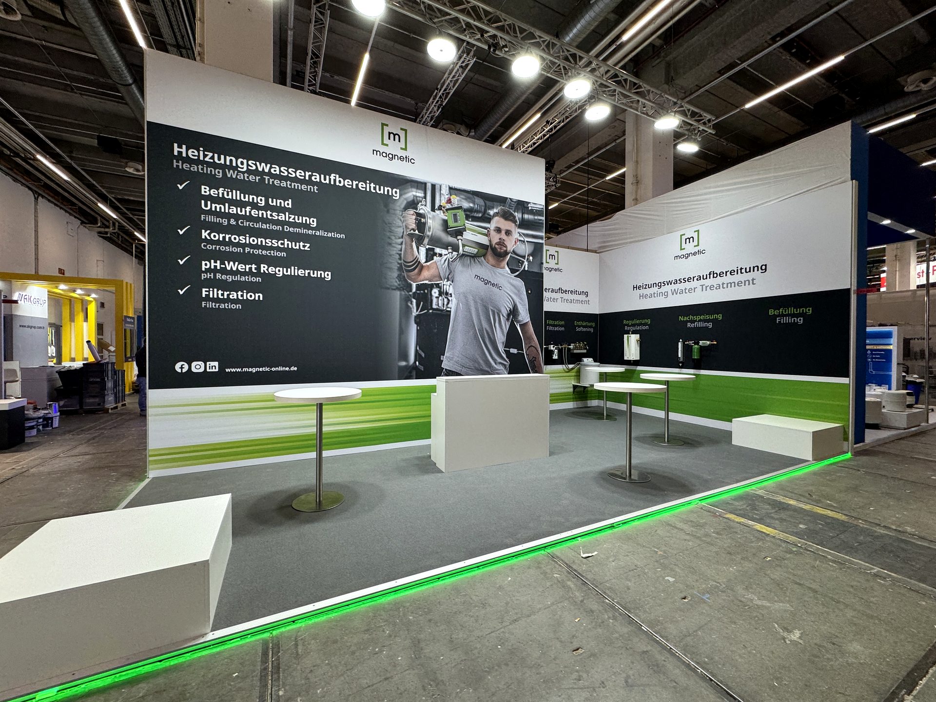 Messestand mit großformatiger Wandgrafik und grünem LED-Boden