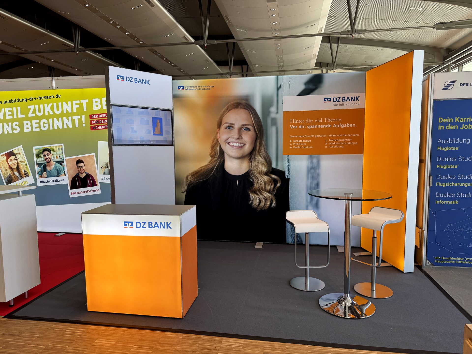 Messestand einer Bank mit Leuchttheke und Monitorwand