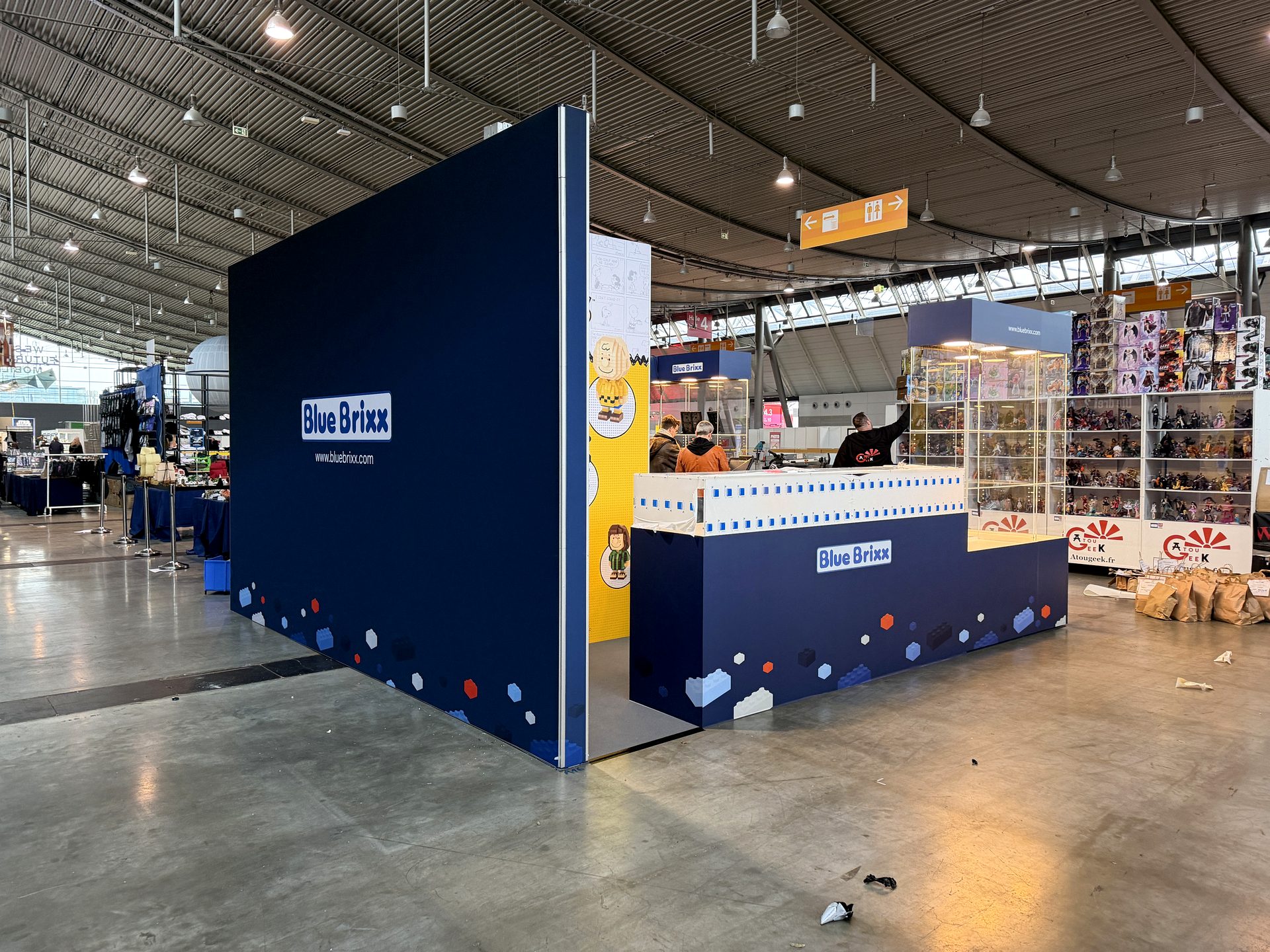 Messestand mit hängender Deckenblende und Vitrinen