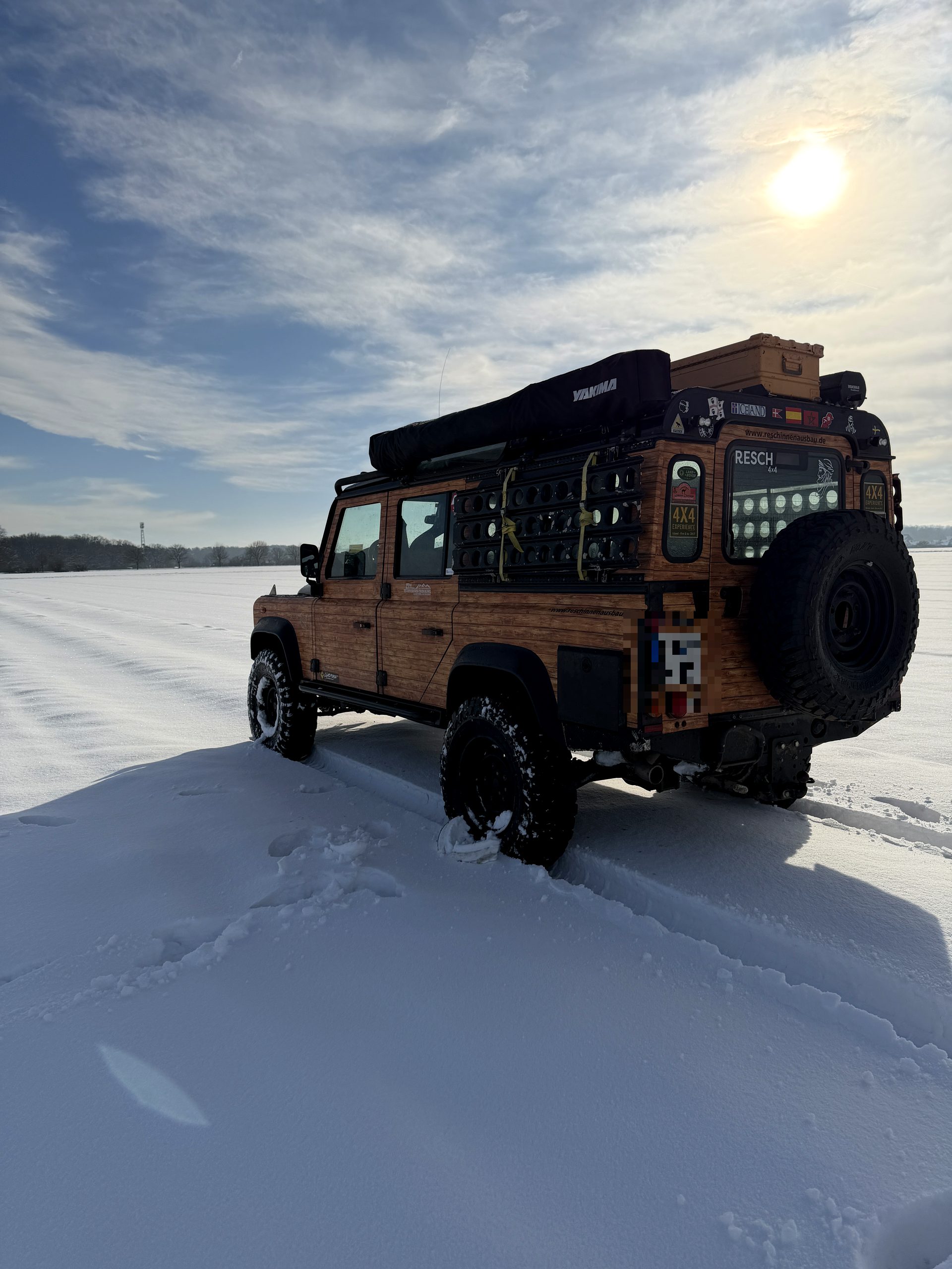 Heckansicht des holzfolierten Defender im Schnee