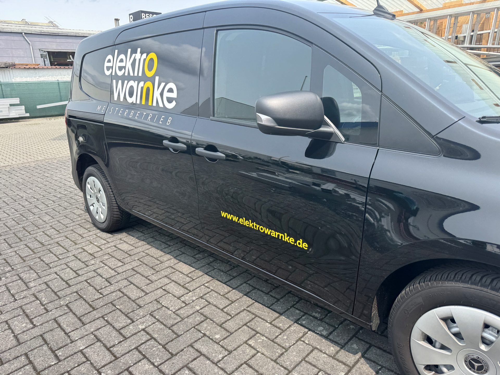 Schwarzer Transporter mit Firmenbeschriftung eines Elektrobetriebs